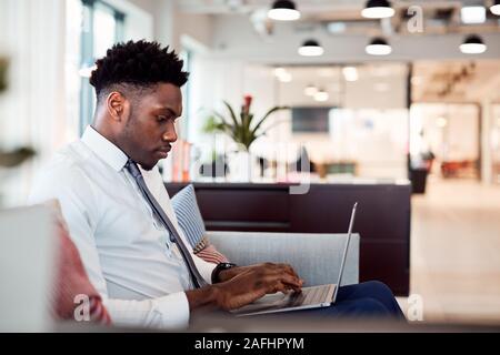 Imprenditore lavora su computer portatile alla reception In Shared Workspace Office Foto Stock