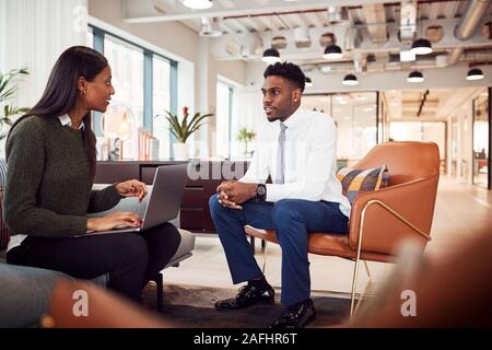 Imprenditrice intervistando maschio Candidato al lavoro in area con posti a sedere di un ufficio moderno Foto Stock