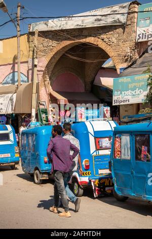 Etiopia, Tigray, Mekele, centro città, Edega, mercato vecchio ingresso ad arco, linea di Bajaj tuk tuk rickshaws Foto Stock