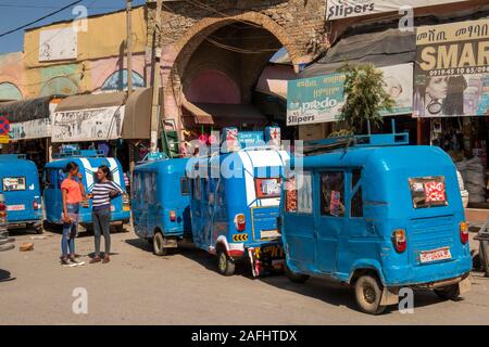 Etiopia, Tigray, Mekele, centro città, Edega, mercato vecchio ingresso ad arco, linea di Bajaj tuk tuk rickshaws Foto Stock