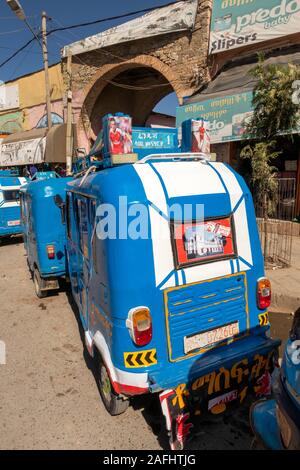 Etiopia, Tigray, Mekele, centro città, Edega, mercato vecchio ingresso ad arco, linea di Bajaj tuk tuk rickshaws Foto Stock