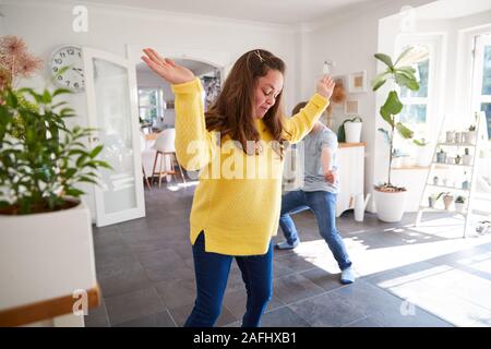 Giovani sindrome Downs giovane avendo divertimento Dancing a casa insieme Foto Stock