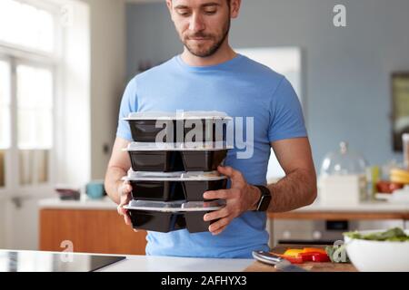 Uomo lotto di preparazione di cibi sani a casa in cucina Foto Stock