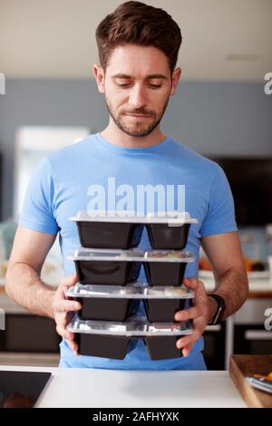 Uomo lotto di preparazione di cibi sani a casa in cucina Foto Stock