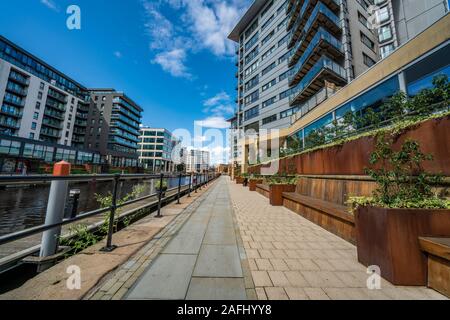 LEEDS, Regno Unito - 13 agosto: Riverside percorso a piedi e moderni edifici sul lungofiume del Dock di Leeds il 13 agosto 2019 a Leeds Foto Stock