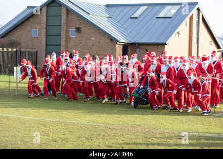 Oxfordshire, Regno Unito - 14 dicembre 2019: persone vestite da Babbo Natale partecipare all'annuale santa fun run. Foto Stock