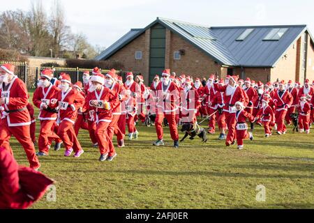 Oxfordshire, Regno Unito - 14 dicembre 2019: persone vestite da Babbo Natale partecipare all'annuale santa fun run. Foto Stock