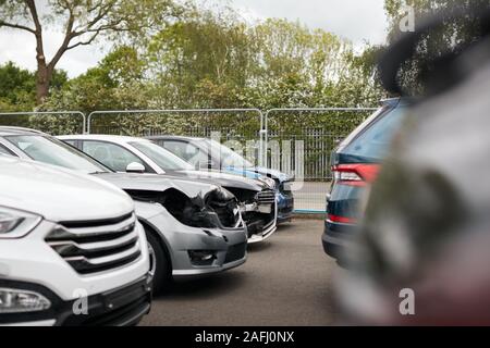 Vetture danneggiate in incidenti automobilistici parcheggiate nel garage negozio di riparazione Foto Stock