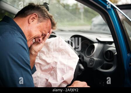 Automobilista maschio ferito in un incidente d'auto con Airbag scattato Foto Stock