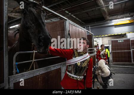 Dietro le quinte con famiglia di cavalleria reggimento montato davanti a loro le prestazioni di quest'anno a Olympia, London International Horse Show, UK. Foto Stock