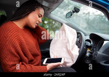 Automobilista femmina ferito in un incidente d'auto dopo l'uso del telefono cellulare durante la guida Foto Stock