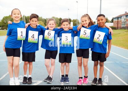 Ritratto di bambini sulla pista di atletica concorrente indossa i numeri sulla giornata di sport Foto Stock