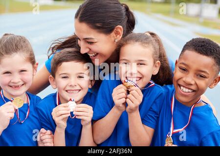 I bambini con pullman femmina di mostrare a tutti i vincitori di medaglie  sulla giornata di sport Foto stock - Alamy