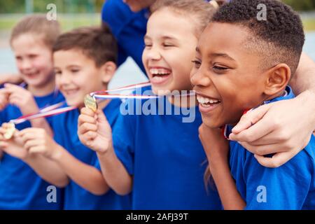 I bambini con pullman femmina di mostrare a tutti i vincitori di medaglie  sulla giornata di sport Foto stock - Alamy