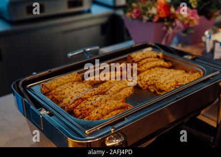 Frittelle in una piastra nella cucina del ristorante pasticceria brea Foto Stock