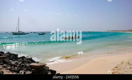 Santa Maria, Sal /Isole di Capo Verde - 19. Novembre, 2015: i pescatori africani il lancio di piccolo skiff di legno da una spiaggia tropicale sulle Isole di Capo Verde Foto Stock