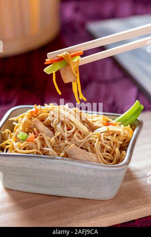 Delizioso pollo-Chow Mein-ricetta con verdure tenere lontano girato in un ristorante con spazio di copia in background ideale per testo sopra i laici Foto Stock