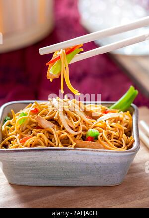 Pollo-Chow Mein-ricetta con verdure tenere lontano girato in un ristorante con spazio di copia in background ideale per testo sopra i laici Foto Stock