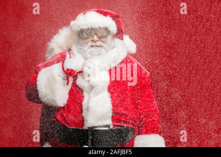 Ritratto di raffreddare fiducioso funky pensionato anziano a santa claus costume borsa sacco nella vigilia di Natale usura tempo cap hat occhiali protettivi la cinghia Foto Stock