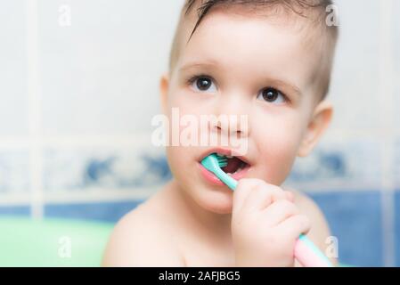 Bellissimo bambino di spazzolare i denti con uno spazzolino da denti in bagno Foto Stock