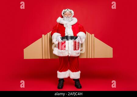 Lunghezza completa foto di anziani funky santa claus in cap hat sono cartone ali craft pronto a volare nella notte di Natale di usura costume magico occhiali protettivi Foto Stock