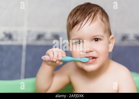 Bellissimo bambino di spazzolare i denti con uno spazzolino da denti in bagno Foto Stock