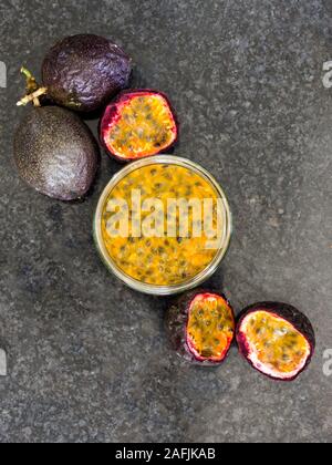 Laici composizione piana che mostra la passione frutta intera e a fette, passione e polpa di frutta Foto Stock