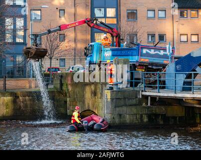 Pulire i detriti e rifiuti in acqua di fiume di Leith da uomini al lavoro da rigidi mondati barca gonfiabile & autocarro con gru, Edimburgo, Scozia, Regno Unito Foto Stock
