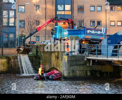 Pulire i detriti e rifiuti in acqua di fiume di Leith da uomini al lavoro da rigidi mondati barca gonfiabile & autocarro con gru, Edimburgo, Scozia, Regno Unito Foto Stock