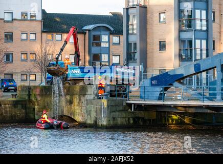 Pulire i detriti e rifiuti in acqua di fiume di Leith da uomini al lavoro da rigidi mondati barca gonfiabile & autocarro con gru, Edimburgo, Scozia, Regno Unito Foto Stock