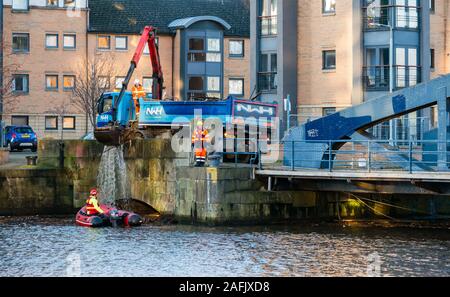 Pulire i detriti e rifiuti in acqua di fiume di Leith da uomini al lavoro da rigidi mondati barca gonfiabile & autocarro con gru, Edimburgo, Scozia, Regno Unito Foto Stock