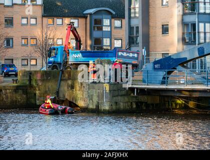 Pulire i detriti e rifiuti in acqua di fiume di Leith da uomini al lavoro da rigidi mondati barca gonfiabile & autocarro con gru, Edimburgo, Scozia, Regno Unito Foto Stock