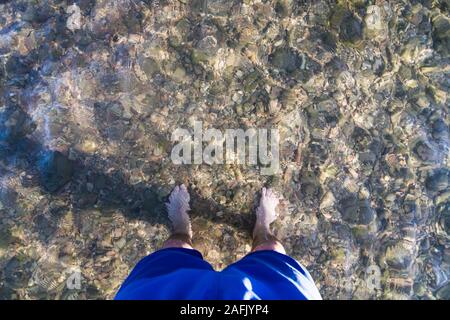 L uomo sta lontano in poco profonda, acqua chiara di Bear Lake, Utah Foto Stock