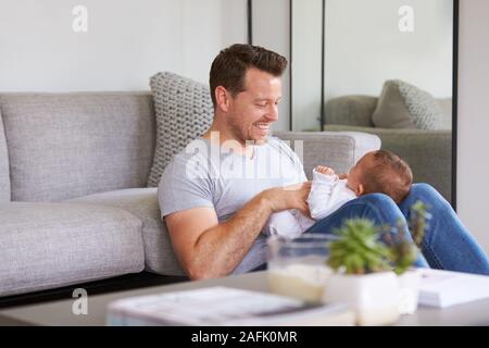 La nostra bambina giacente sul giro dei Padri come gioca il gioco con lei a casa Foto Stock