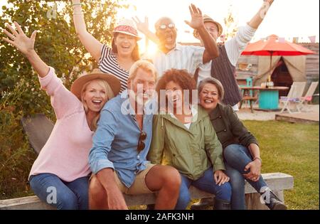Ritratto di coppia amici seduti intorno al fuoco a campeggio all'aperto Foto Stock