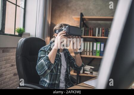 Uomo bello indossare un nuovo auricolare VR Foto Stock