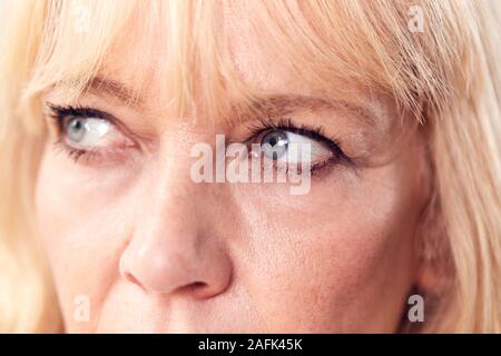 Studio ravvicinata di una donna matura in cerca di sospetto e di sfiducia Foto Stock