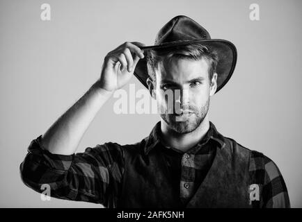 Cowboy indossando un cappello. American cowboy. Standard di bellezza. Esempio di vera mascolinità. Vita occidentale. Uomo barba lunga cowboy sfondo beige. Barba lunga ragazzo nel cappello da cowboy. Bello barbuto macho. Foto Stock