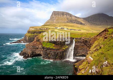 Cascata Gasadalur dal punto di vista durante una soleggiata giornata autunnale con l'acqua proveniente fino sotto un forte vento (Isole Faerøer, Danimarca, Europa) Foto Stock