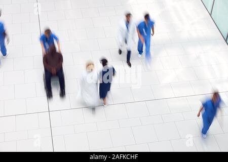 Vista aerea del personale medico a piedi attraverso la Lobby del moderno edificio dell ospedale con Motion Blur Foto Stock