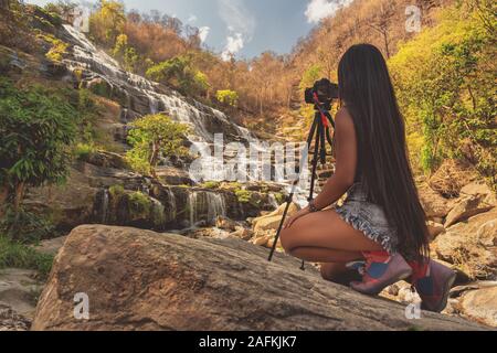 Bella donna fare foto Mae Ya cascata è una delle più belle cascate in Doi Inthanon parco nazionale, Chiang mai. Foto Stock