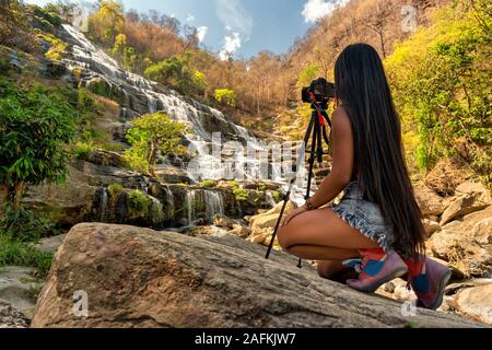 Fotografo di viaggio attivo di stile di vita fare foto cascata Mae Ya è una delle più belle cascate di Doi Inthanon, Chiang mai Foto Stock