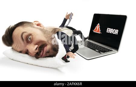 Lavoro non andare su, non ha le trattative. Grande testa sul piccolo corpo giacente sul cuscino. Un uomo non può svegliarsi e a piedi a lavorare "provocare mal di testa e overslept. Concetto di business, di lavoro, di fretta fino, i limiti di tempo. Foto Stock