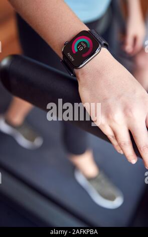 Close up della donna che esercitano sul tapis roulant indossando Smart Watch Foto Stock