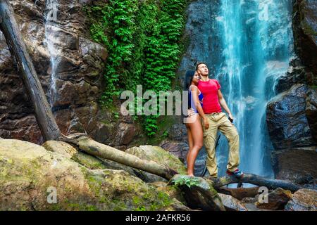 Coppia abbracciando e baciare sotto le cascate. Foto Stock