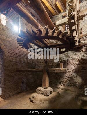 Età mulino ad acqua ruotando all'interno del mulino a spiovente edificio a Amir Taz Palazzo Medievale, Il Cairo, Egitto Foto Stock