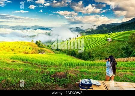 Donna di viaggio fare foto paesaggio natura e godere di vista paesaggio risaia terrazza in Asia al sorgere del sole. Stile di vita attivo e concetto di viaggio Foto Stock