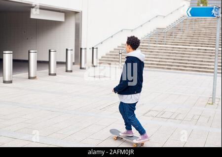 Giovane Donna cavallo su skateboard attraverso il sottopassaggio della città Foto Stock