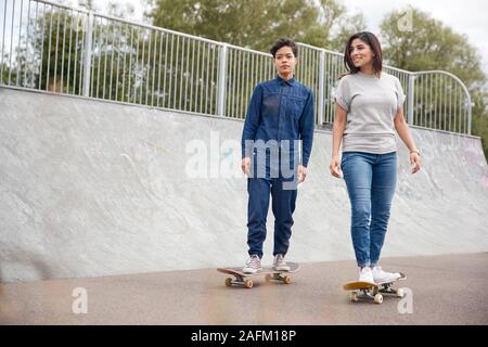 Giovane Donna cavallo su skateboard in Urban Skate Park Foto Stock