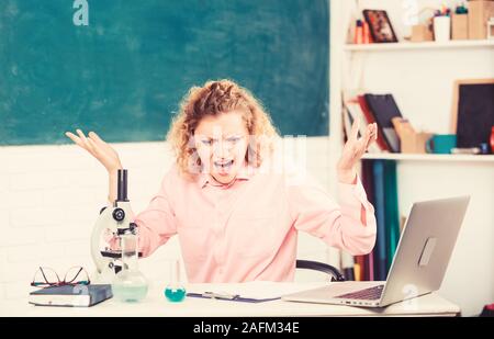 Femmina emotiva formatori d insegnanti in aula lavagna sfondo. Persone emotive del concetto. Donna tutor o studente alla scrivania con computer portatile e attrezzature scolastiche articoli di cancelleria. Controllo emotivo. Foto Stock